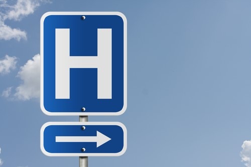 A blue hospital sign pointing in the direction of the hospital.